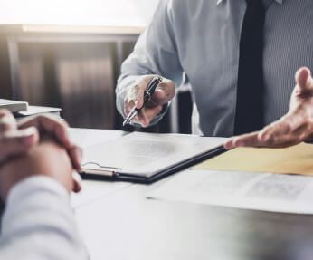 Real Estate Attorney in Lynbrook, NY Reviewing a Document with a Client