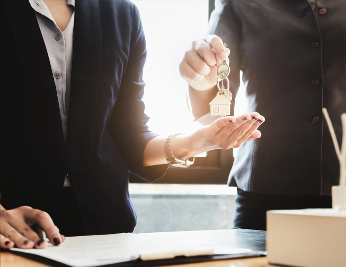 Real Estate Attorney handing keys over to client after helping purchase a home in Roslyn, NY