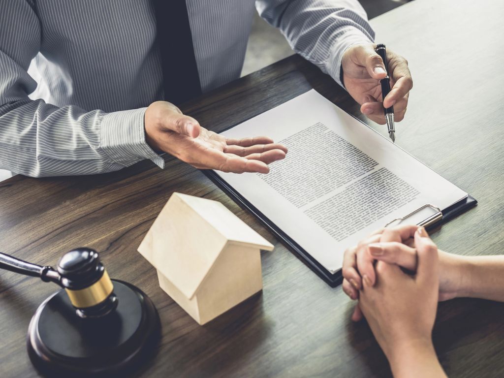 Real Estate Attorney in Oceanside, NY Discussing a Contract with a Client