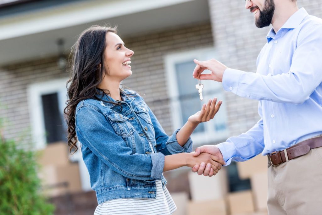 Couple Smiling with New Keys After Working with a Real Estate Attorney in Hempstead, New York